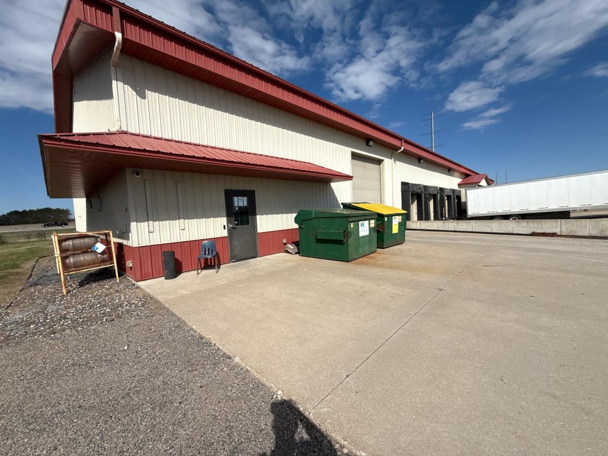 Commercial building with a red metal roof and white gutters and downspouts in Clearwater, MN