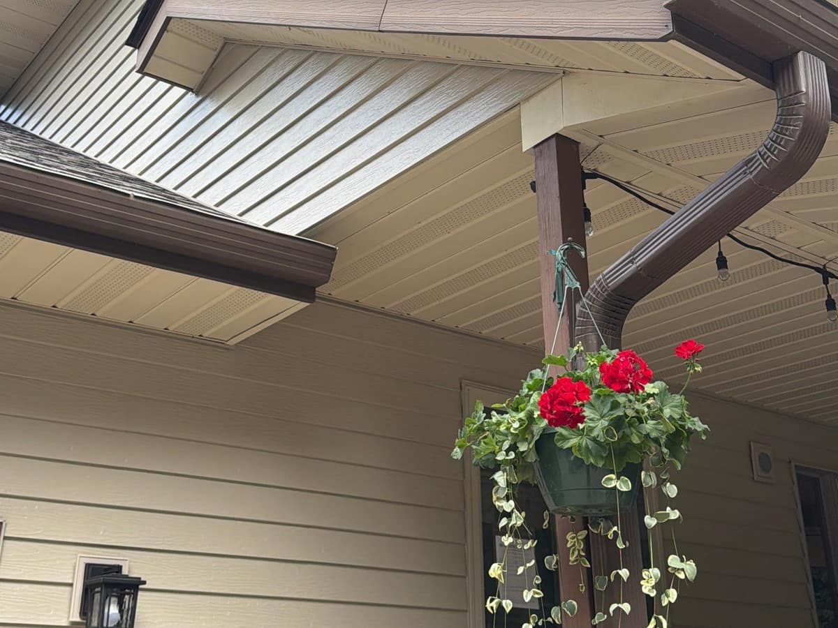 Brown seamless gutter and downspout on tan siding of a home in Cold Spring, MN