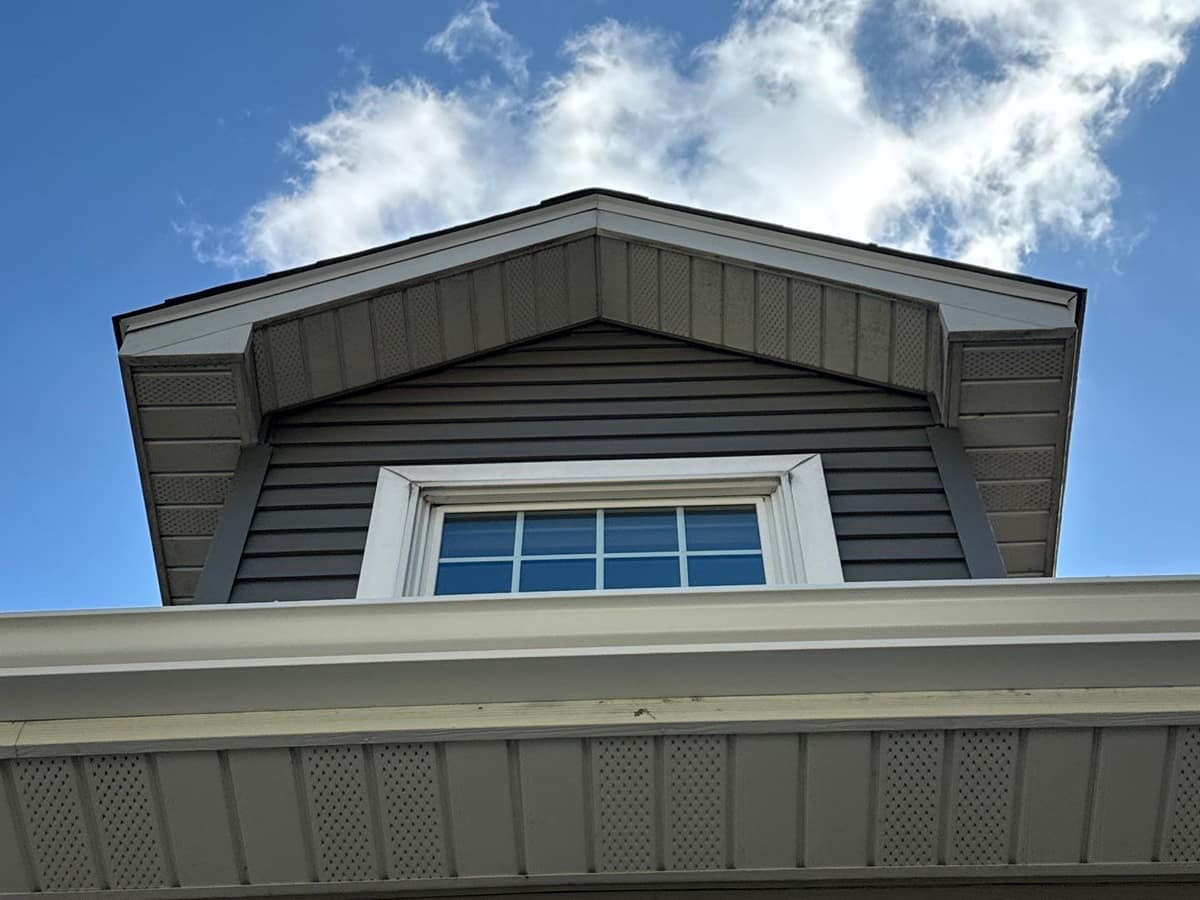 Gray lap siding, white trim and a gutter under a dormer window in Cold Spring, MN