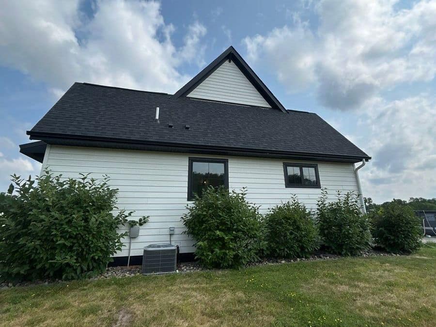 New black asphalt shingle roof on a white farmhouse-style home in Foley, MN
