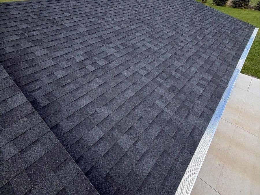 New black shingle roof running down to a white gutter at the eave in Foley, MN