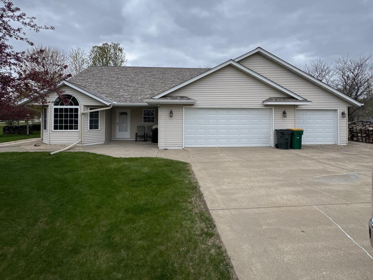 Beige home with a new gray-brown shingle roof and attached three-car garage in Kimball, MN