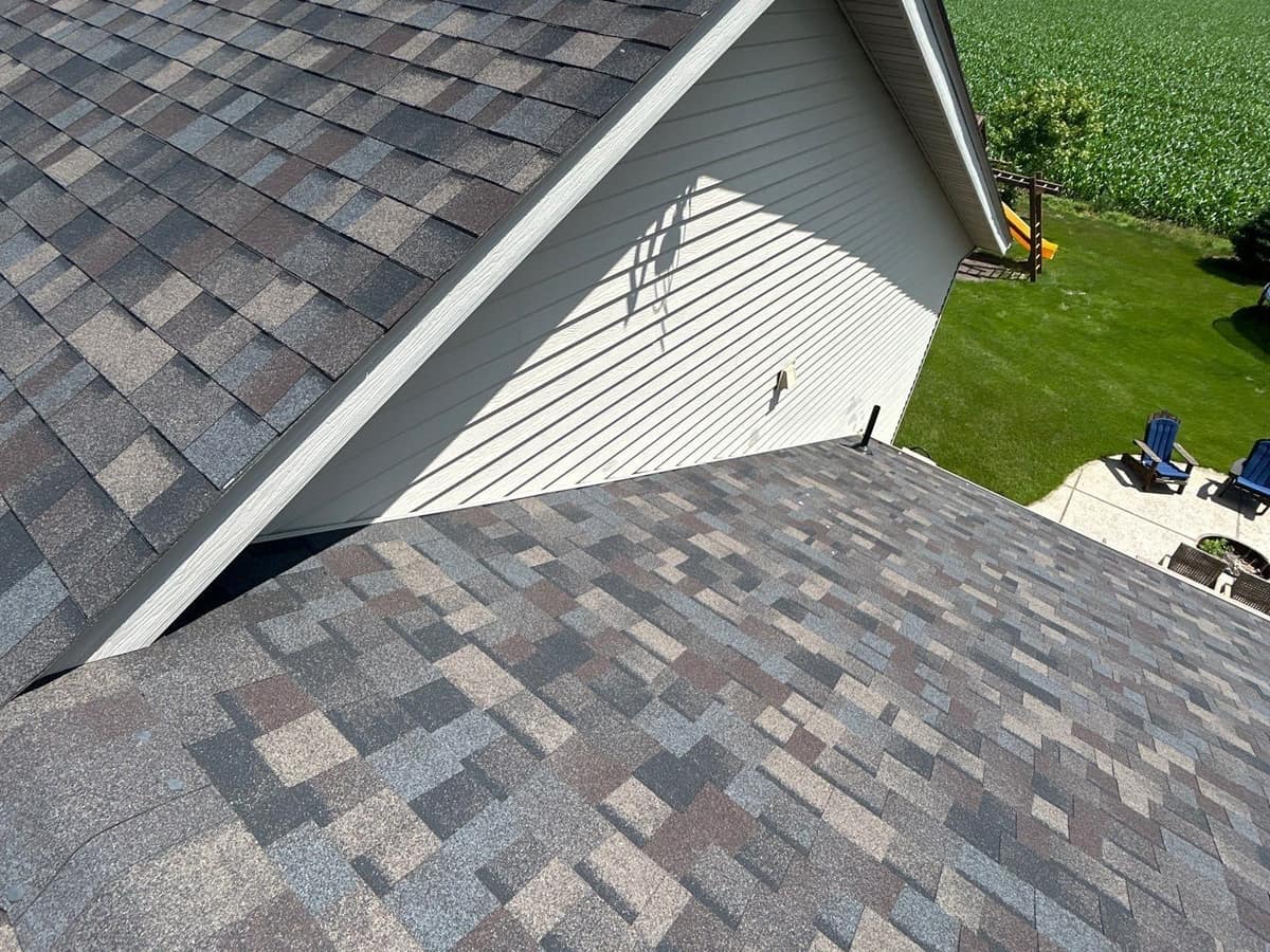 New multicolor architectural shingle roof with farm fields beyond in Kimball, MN
