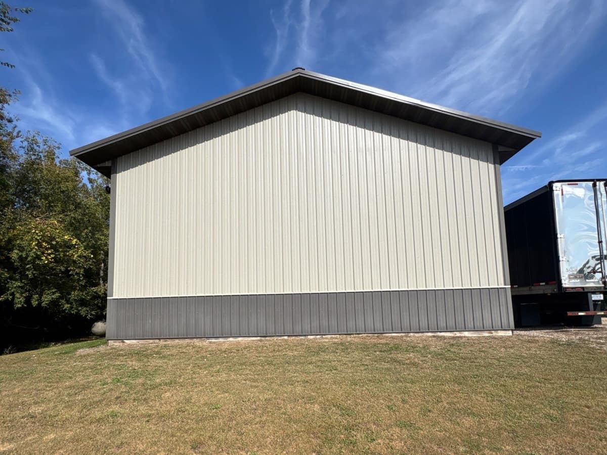 Tan and charcoal steel siding and metal roof edge on a shop building in Kimball, MN