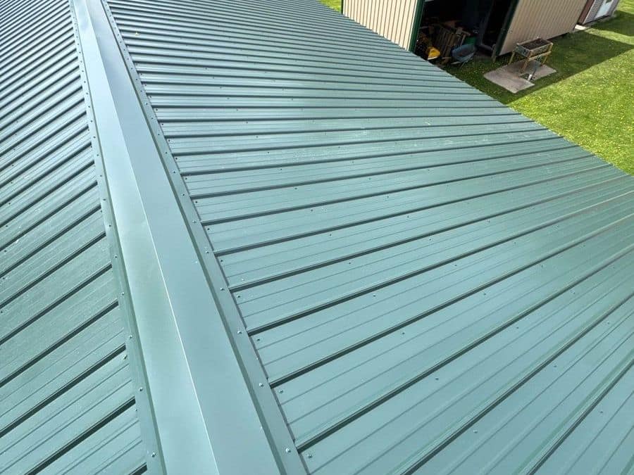 New green metal roof running down to a ridge cap in Milaca, MN