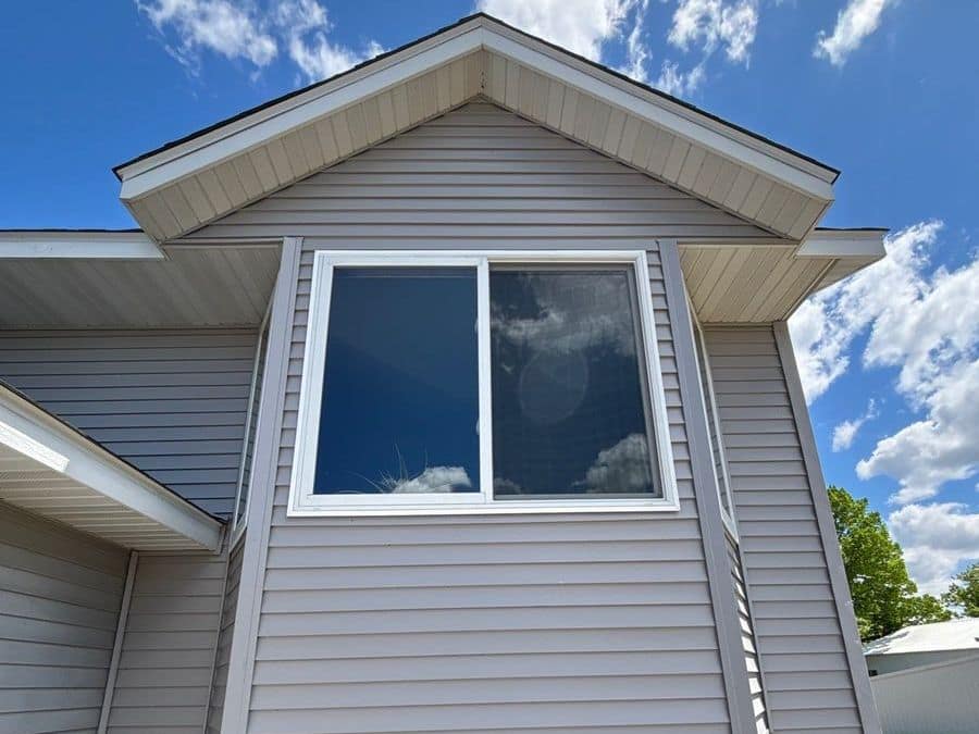 Gray vinyl siding around a bay window with white trim on a home in Rice, MN