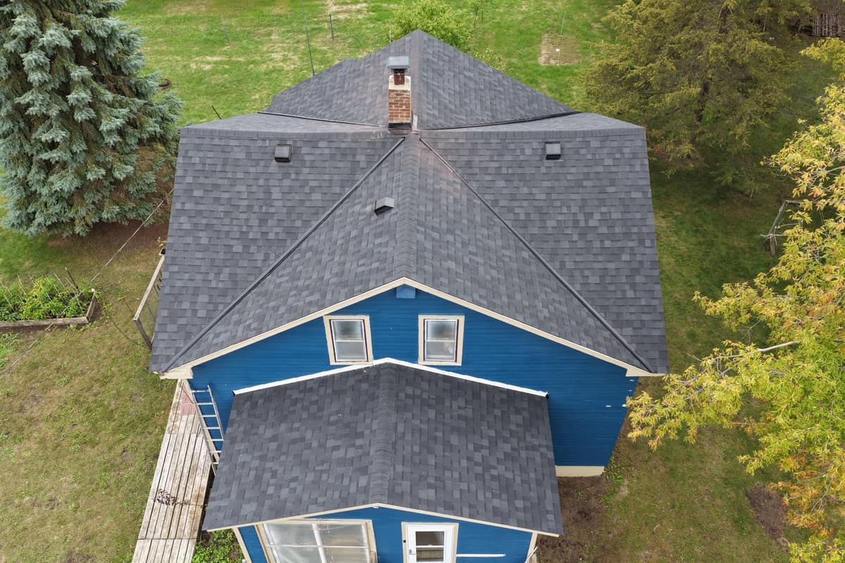 Drone view of a new charcoal shingle roof on a blue two-story home in Sartell, MN