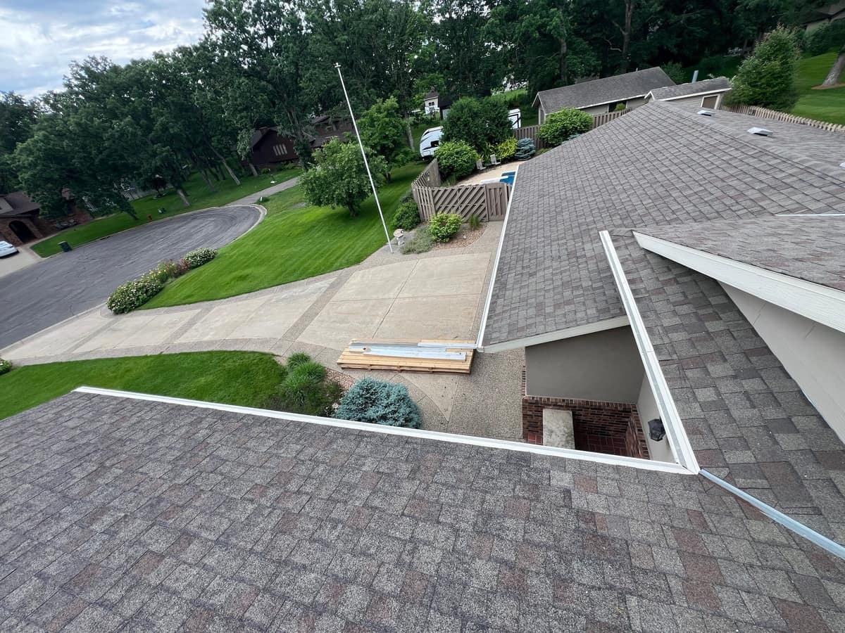 Completed multi-level shingle roof with white drip edge in Sartell, MN
