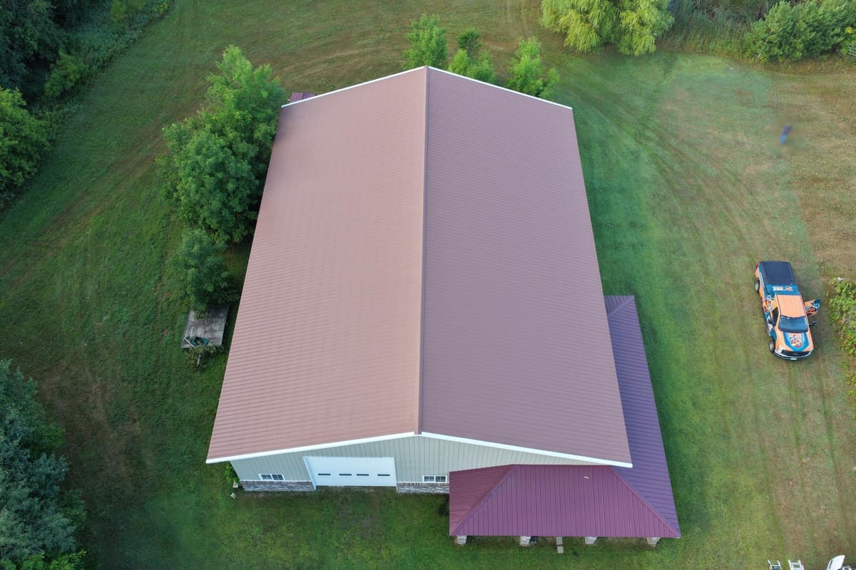 Drone view of a brown metal roof and maroon porch roof on a large shop building in St. Augusta, MN