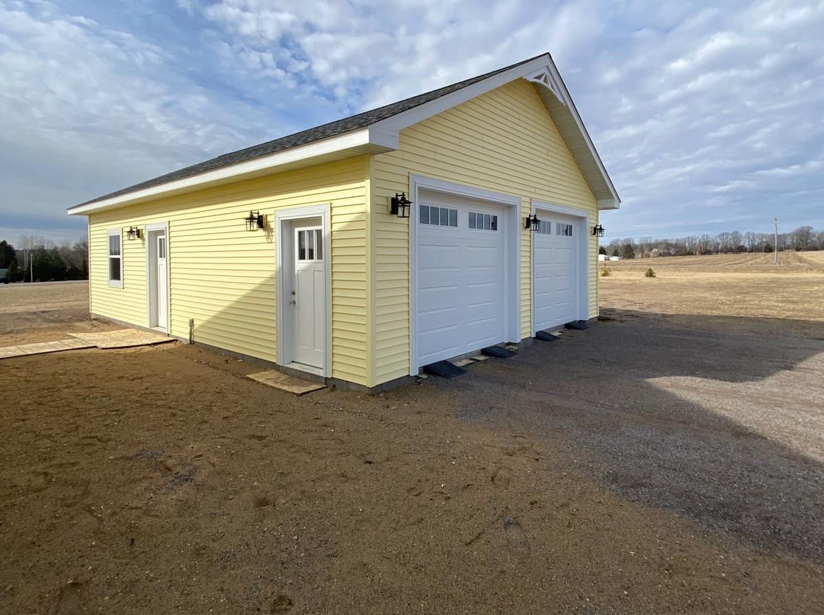 Yellow lap siding and a shingle roof on a detached two-car garage in St. Joseph, MN