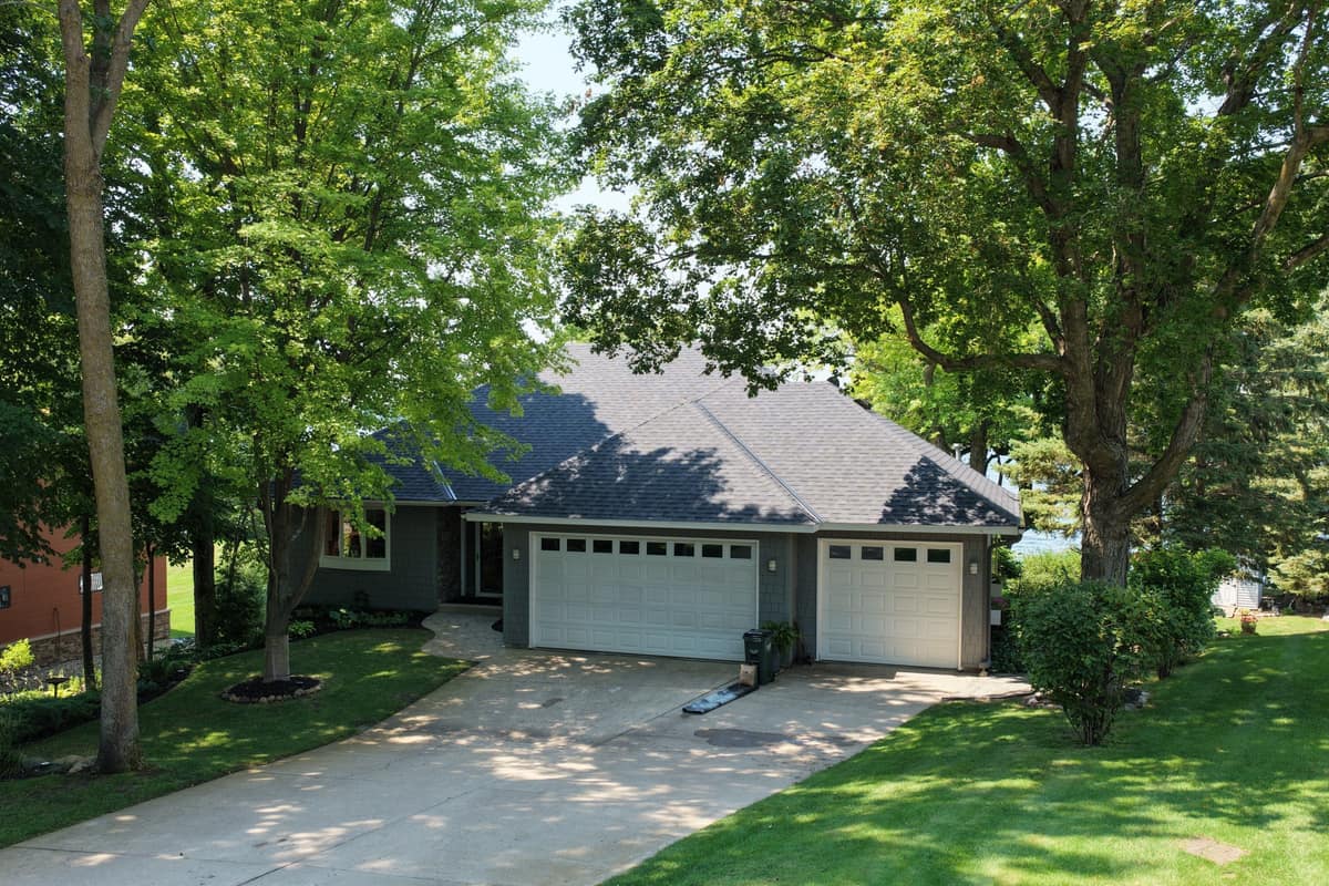 Drone view of a finished charcoal shingle roof on a hip-roof home with a two-door garage in Alexandria, MN