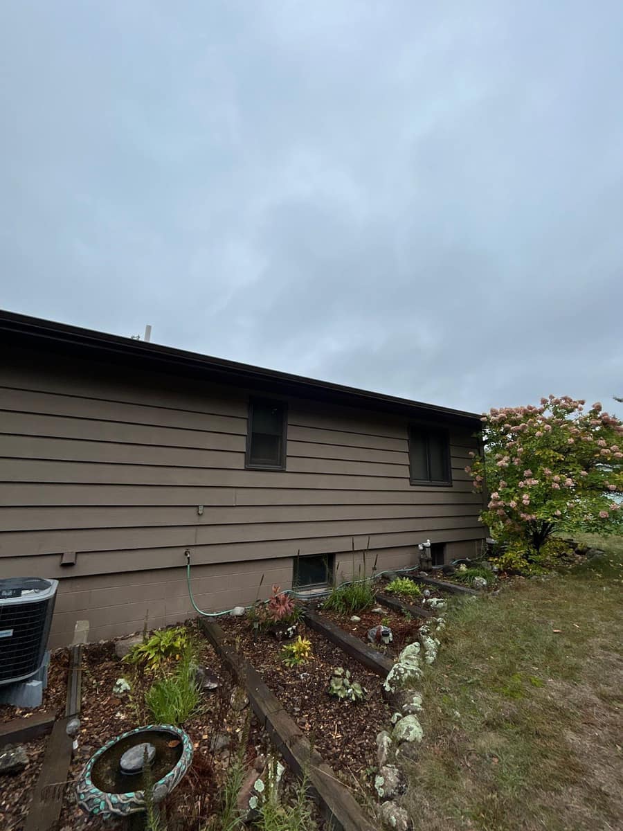 Long side of the Baxter home with new dark fascia and gutter along the roof edge