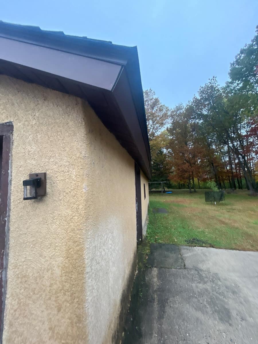 New brown fascia and shingle edge along a stucco wall in Brainerd