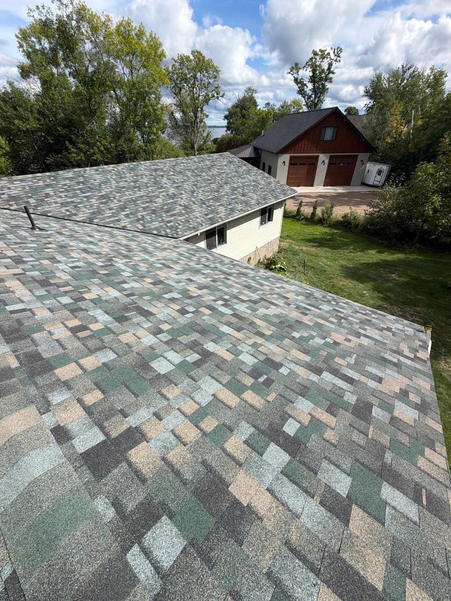 New multi-tone shingles on the Brainerd roof with a detached garage in the background