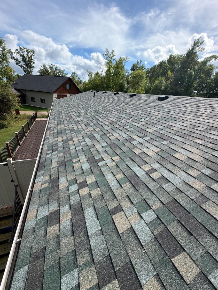 Long run of new shingles above a new gutter on the Brainerd home