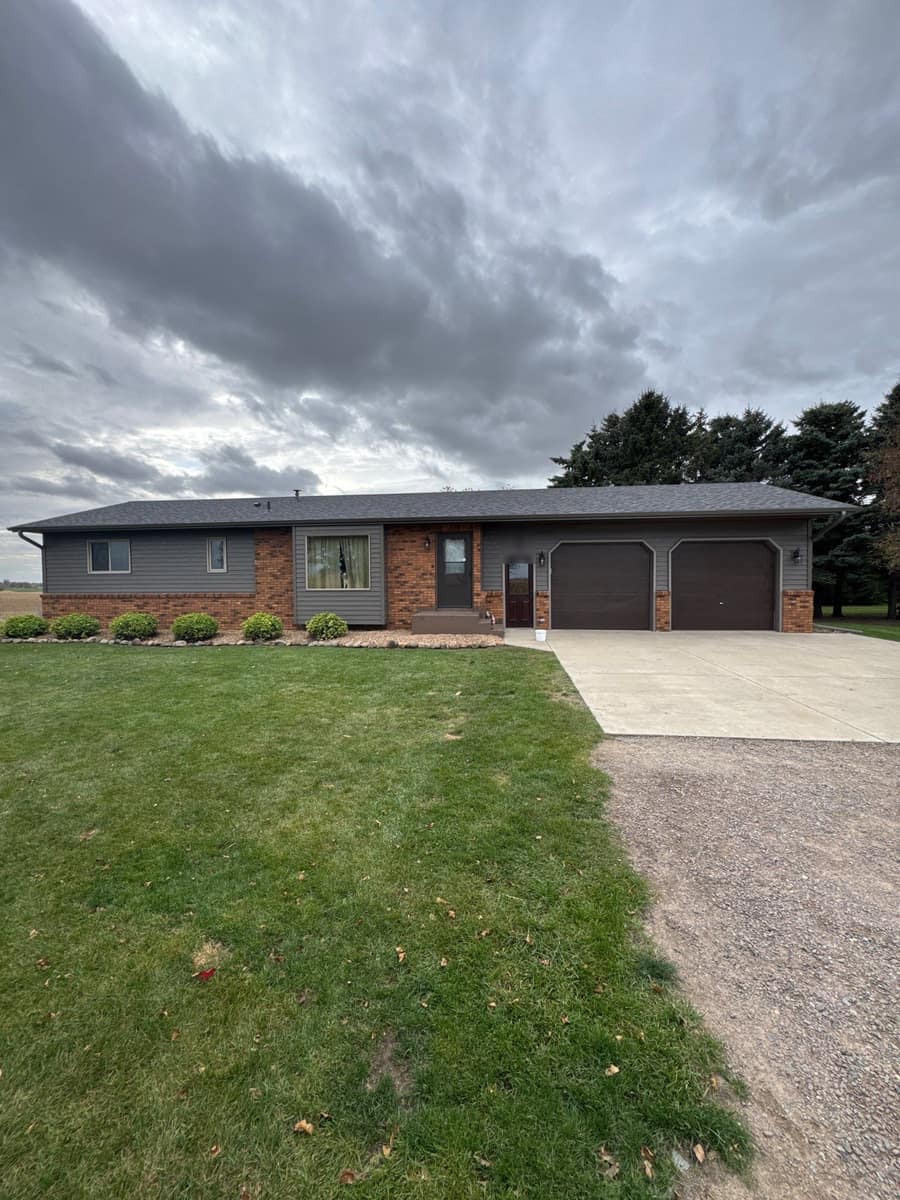 Front of a Cold Spring, MN rambler with new gray siding, red brick accents and a new shingle roof