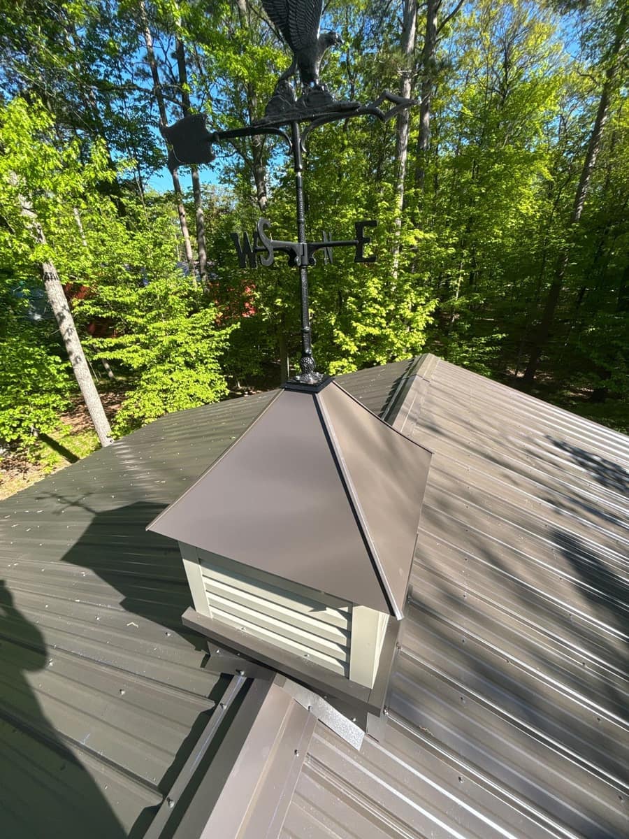 Cupola and weathervane on top of the new steel roof in Crosslake, MN