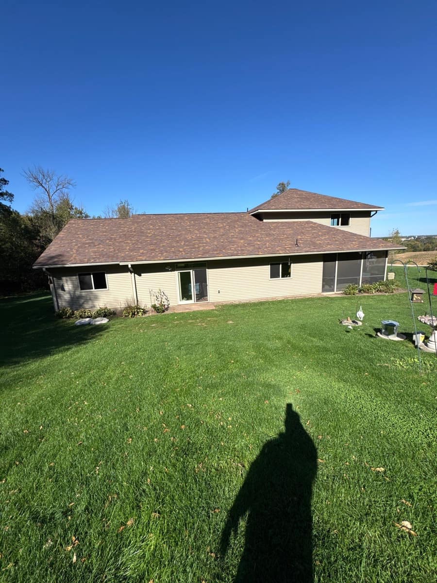 Back of a Kimball, MN home with long single-story wings under a new brown blend shingle roof