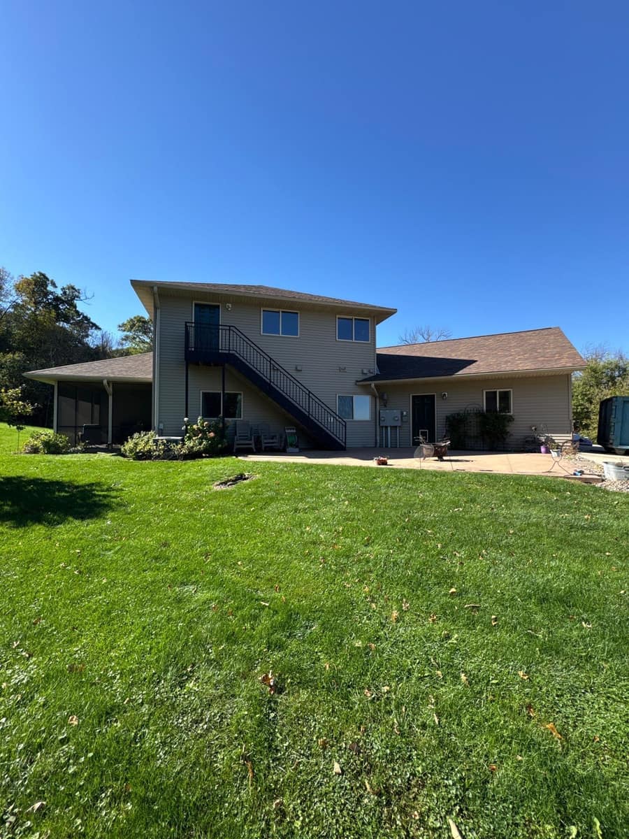 Two-story center of the Kimball home with an exterior stair and the new brown roof