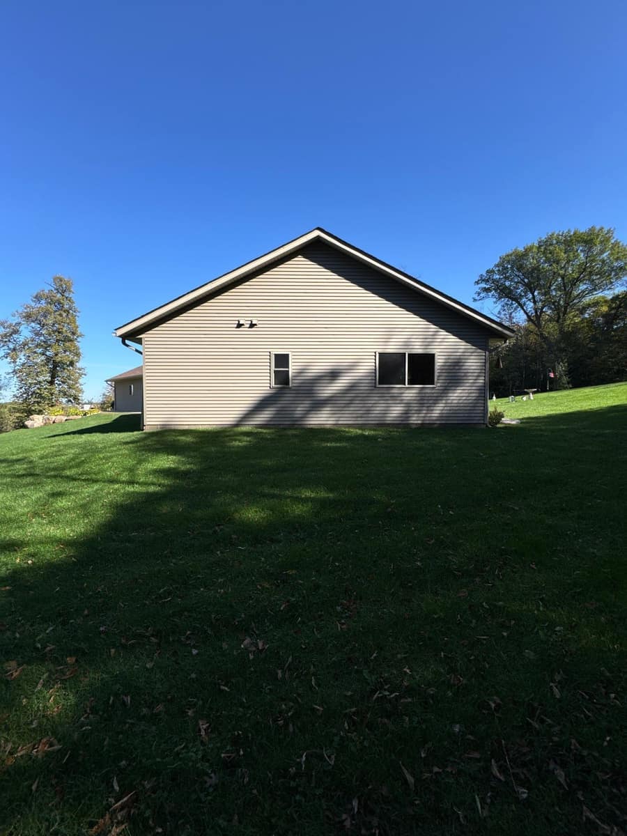 Gable end of the Kimball home with beige siding under the new roof line