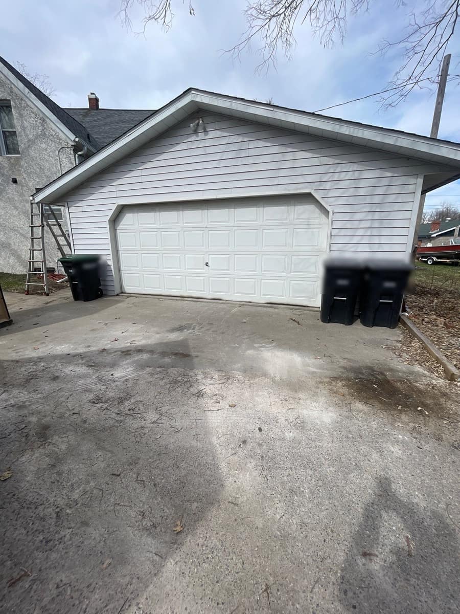 Detached two-car garage in Little Falls, MN with a new gray shingle roof