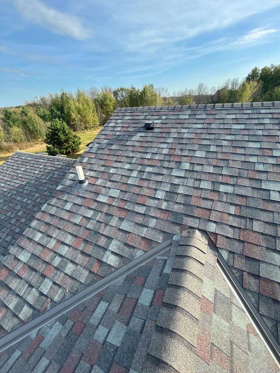 Gray valley metal and vents on the new gray and red blend shingle roof in Milaca