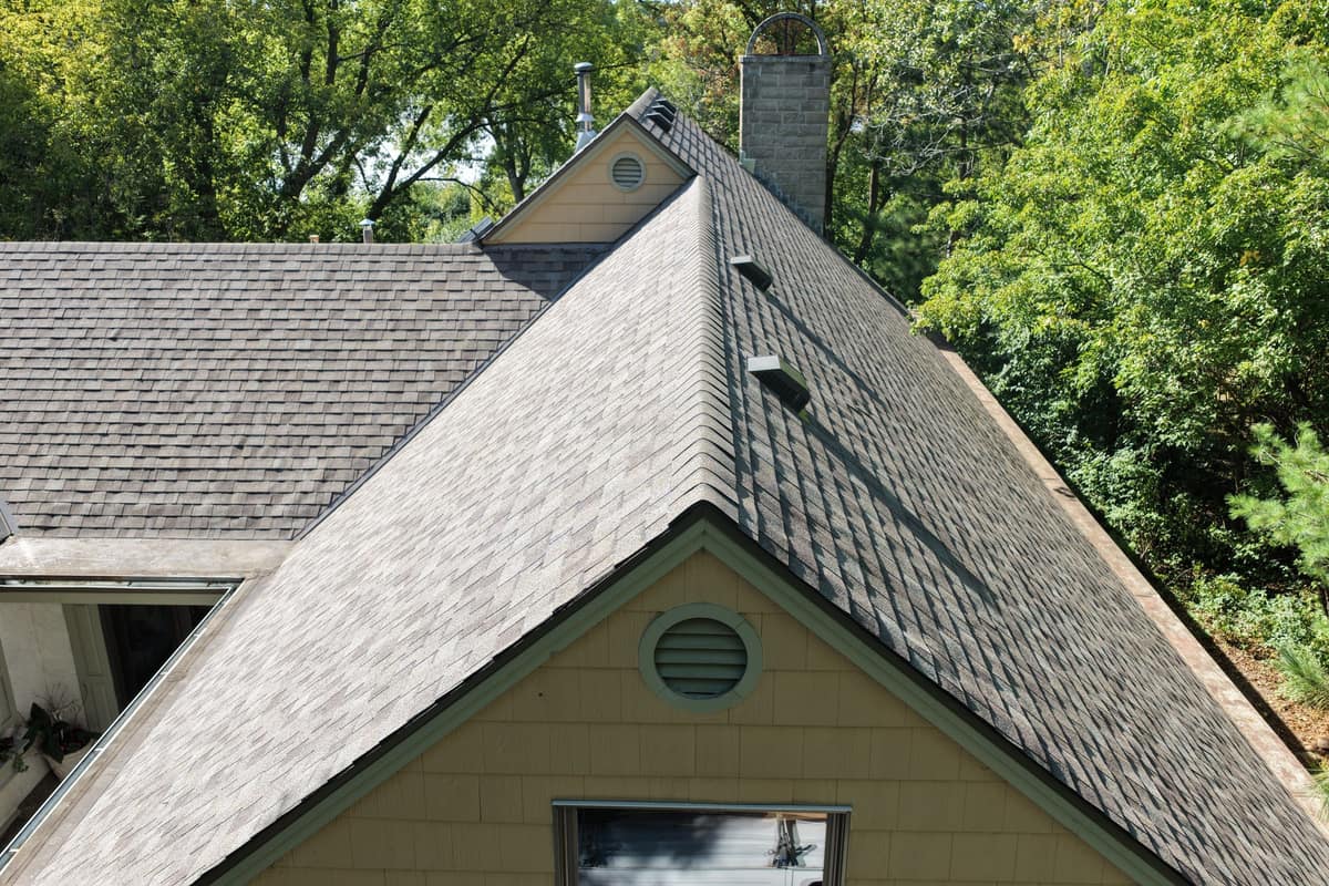 Drone view of a new shingle ridge above a cream gable with a round vent in Minnetonka