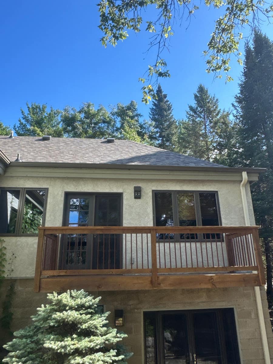 Rear elevation of the Minnetonka home with a balcony under the new roof