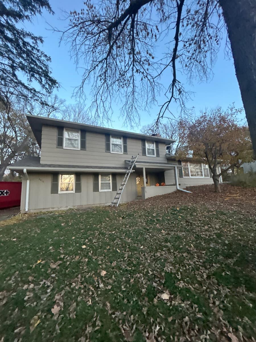 Two-story Minnetonka home with gray lap siding after a new shingle roof in late fall