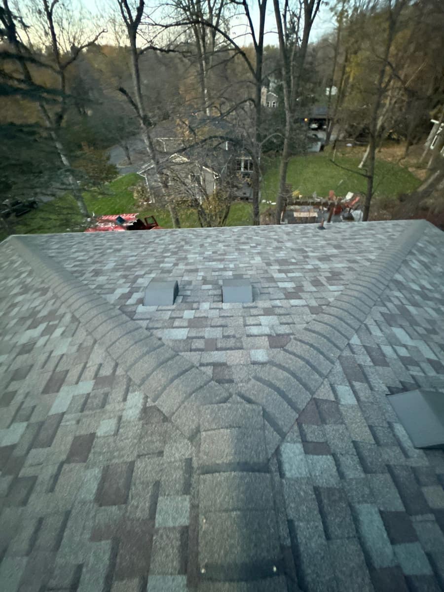 New shingles meeting at a hip with roof vents near the peak in Minnetonka