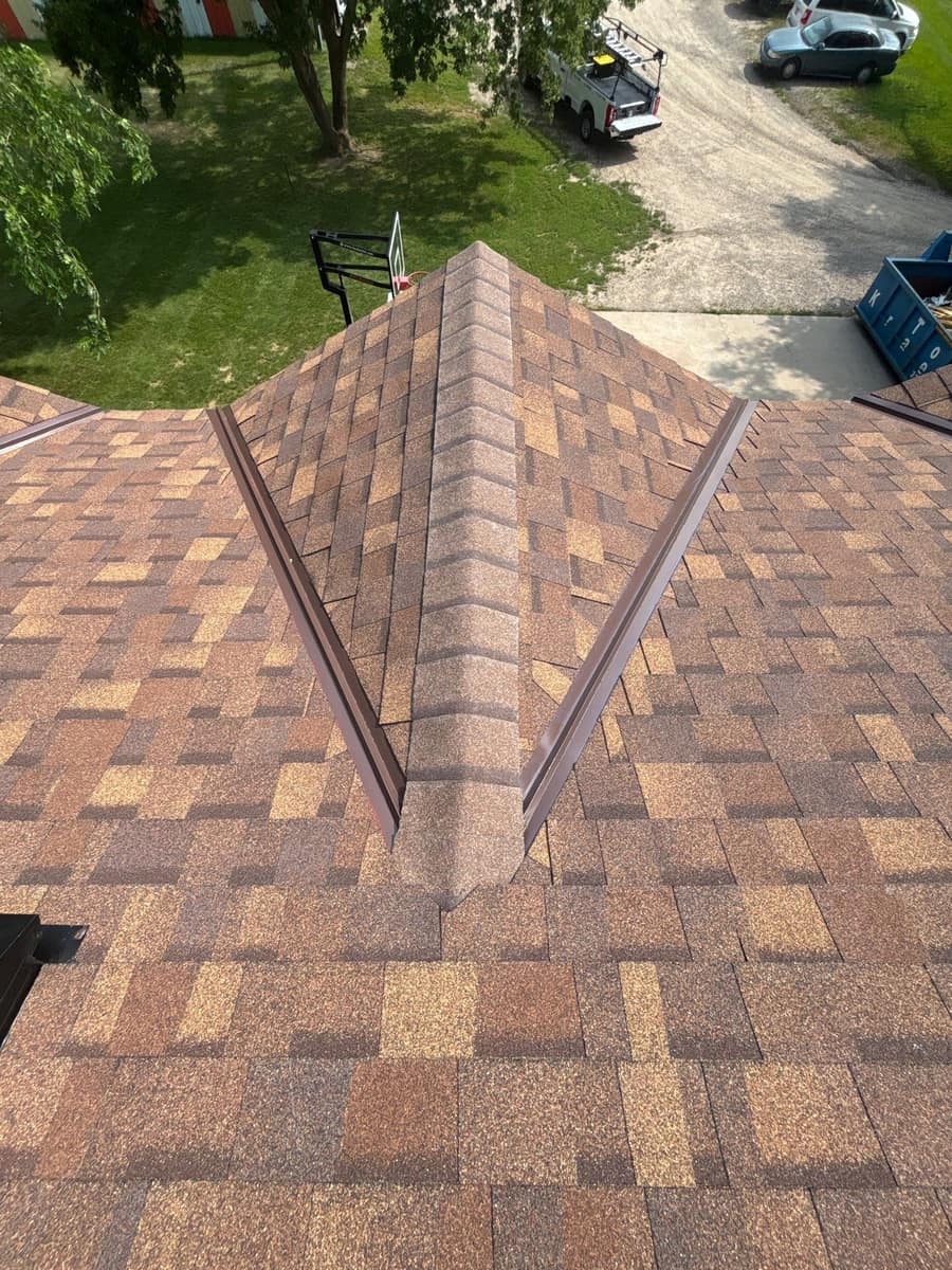 New brown blend shingles with metal valleys at a hip in Monticello