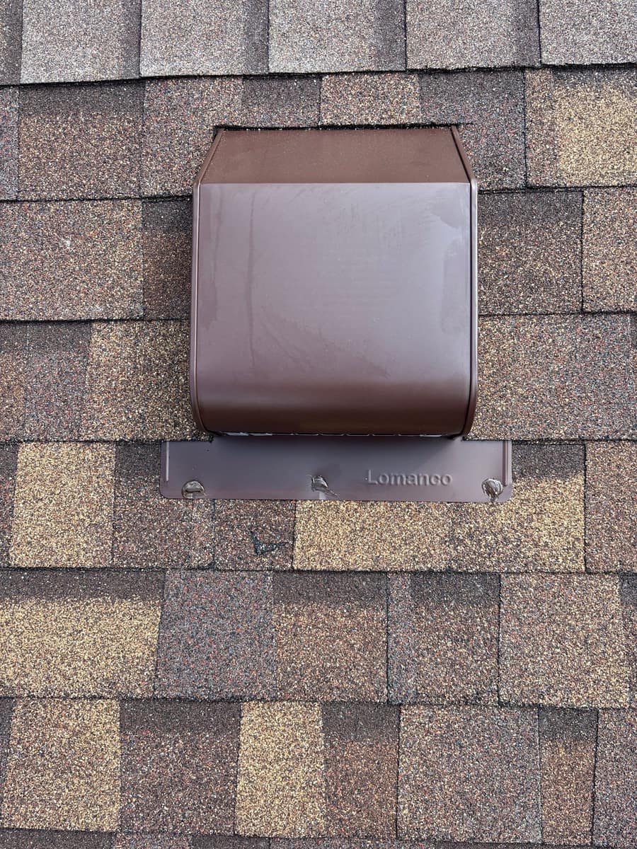 Close view of a brown roof vent set into new shingles in Monticello