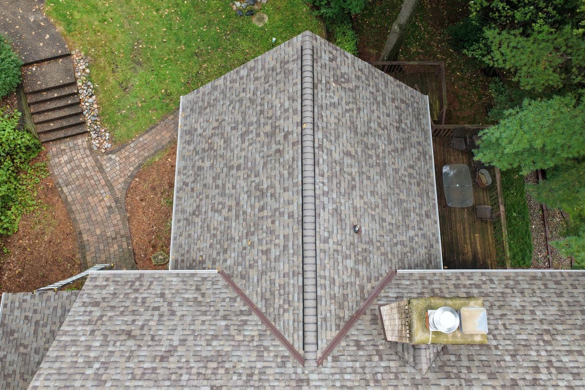 Drone view of a finished brown blend shingle roof on a wooded Nisswa, MN home