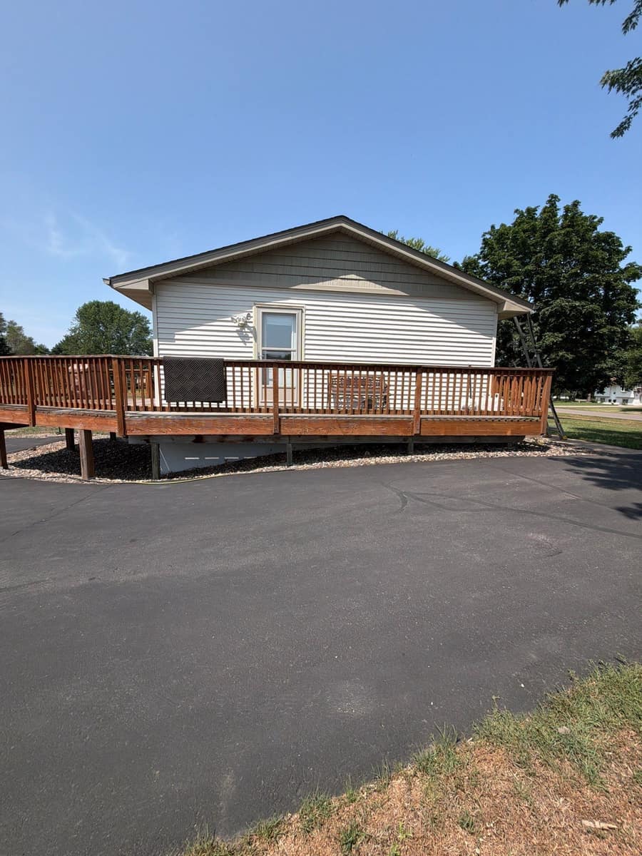Back of a ranch home in Otsego, MN with a large deck under a new gray shingle roof