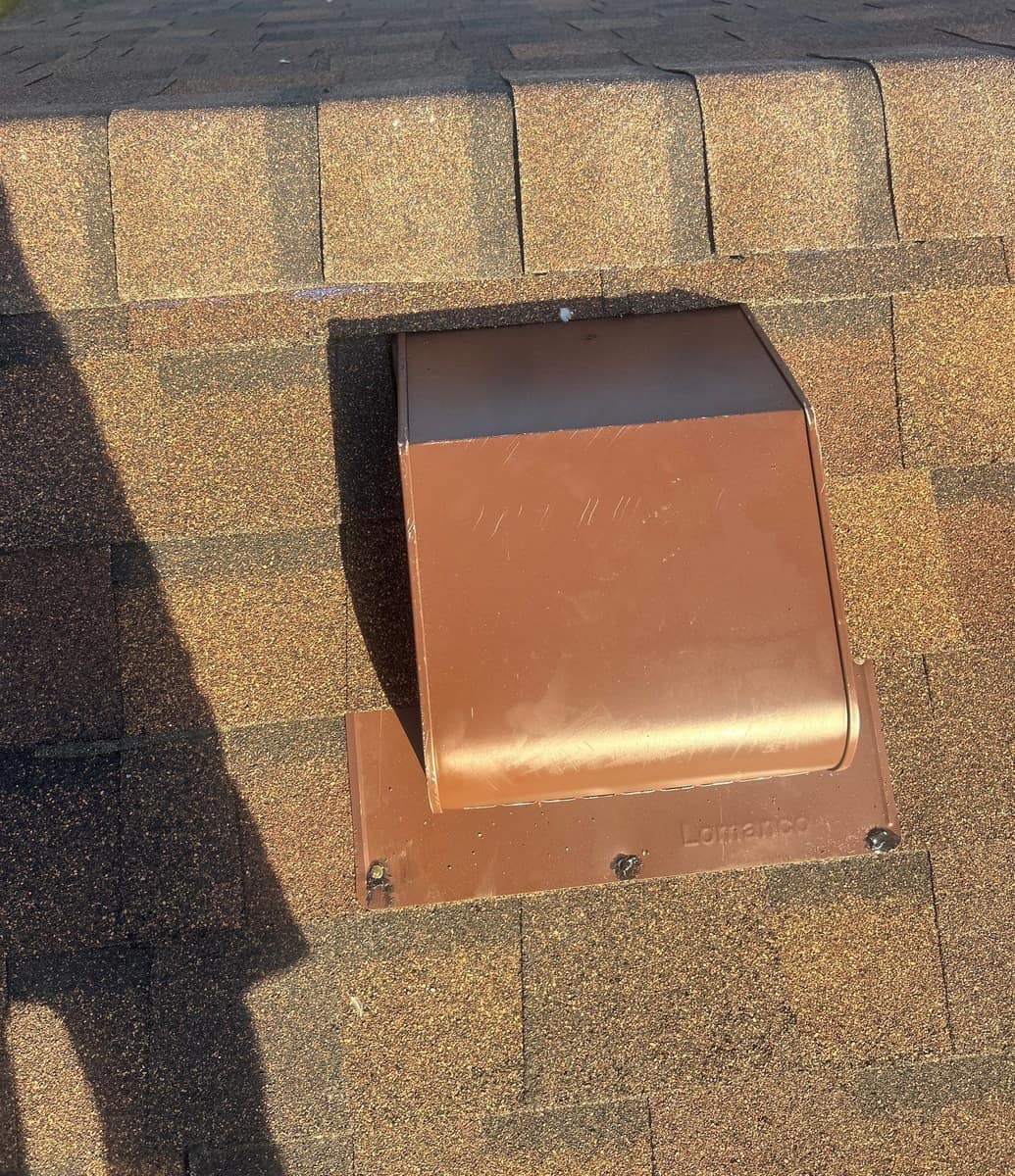 Brown box vent with shingles lapped over its flange on the new roof in Rice, MN
