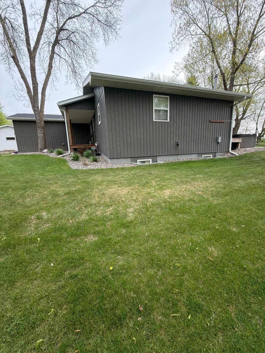 Lakeside home in Richmond, MN with gray vertical siding under a new dark gray shingle roof