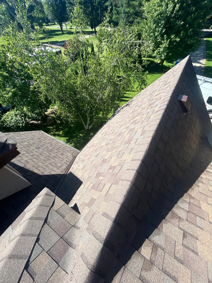 Steep roof plane with new shingles and a roof vent in Sartell