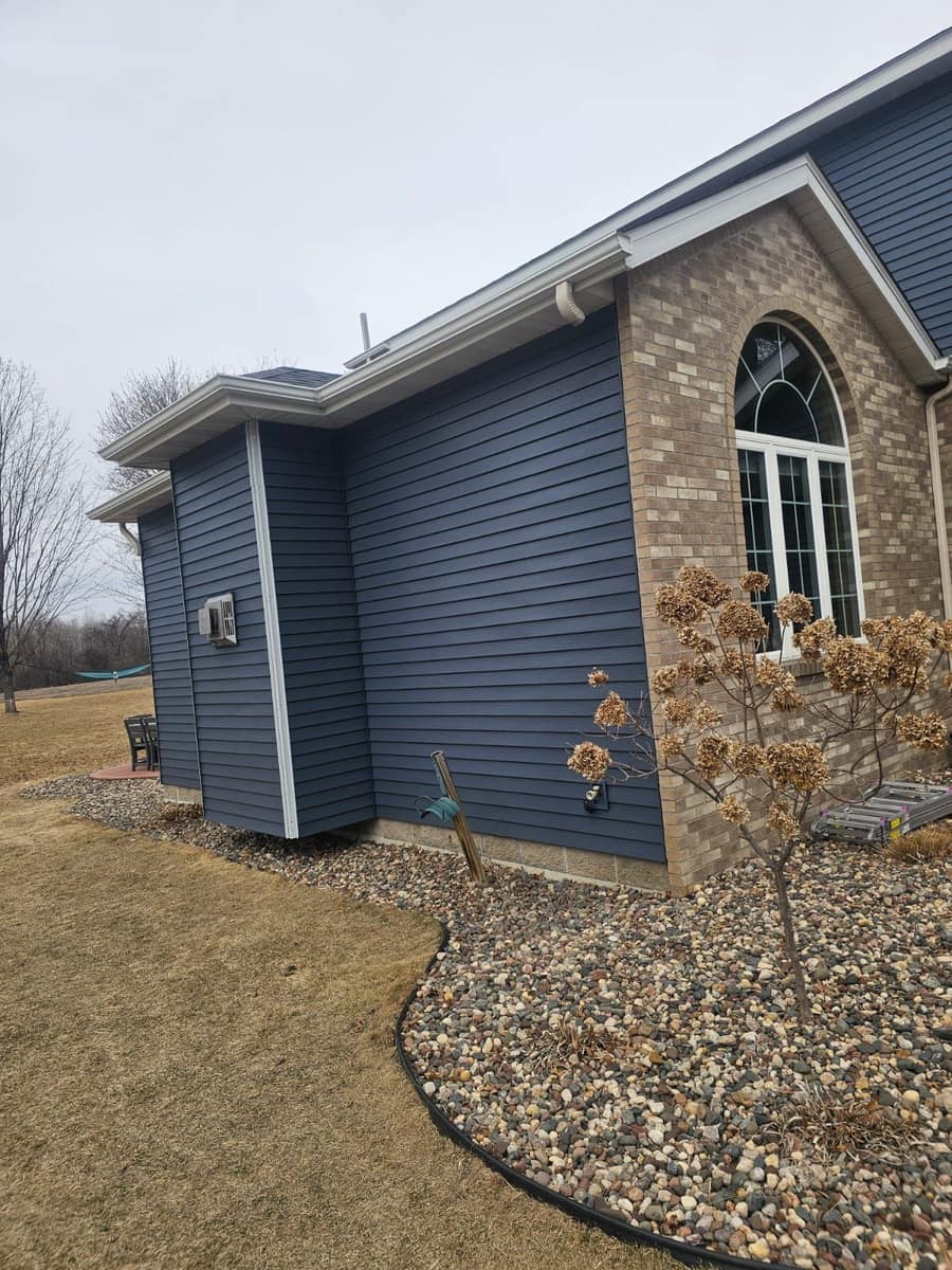 Two-story Sartell home with new blue steel siding, a stone accent column and a new roof