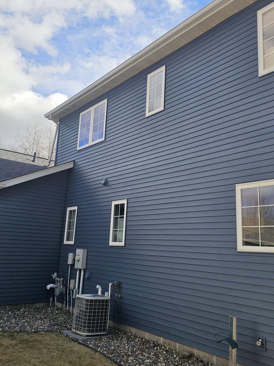 Tall side wall of the Sartell home covered in new blue steel siding