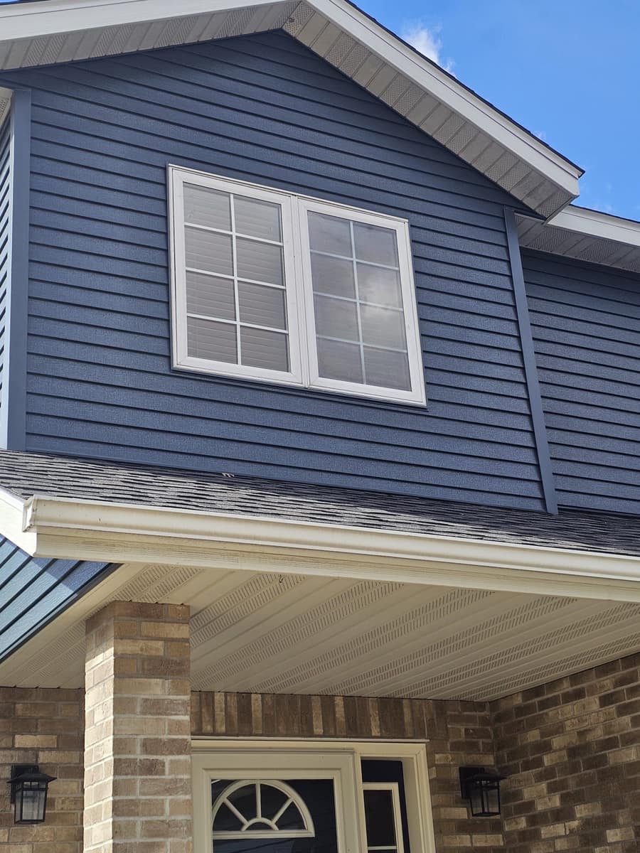 Front entry soffit and gutter below new blue siding on the Sartell home
