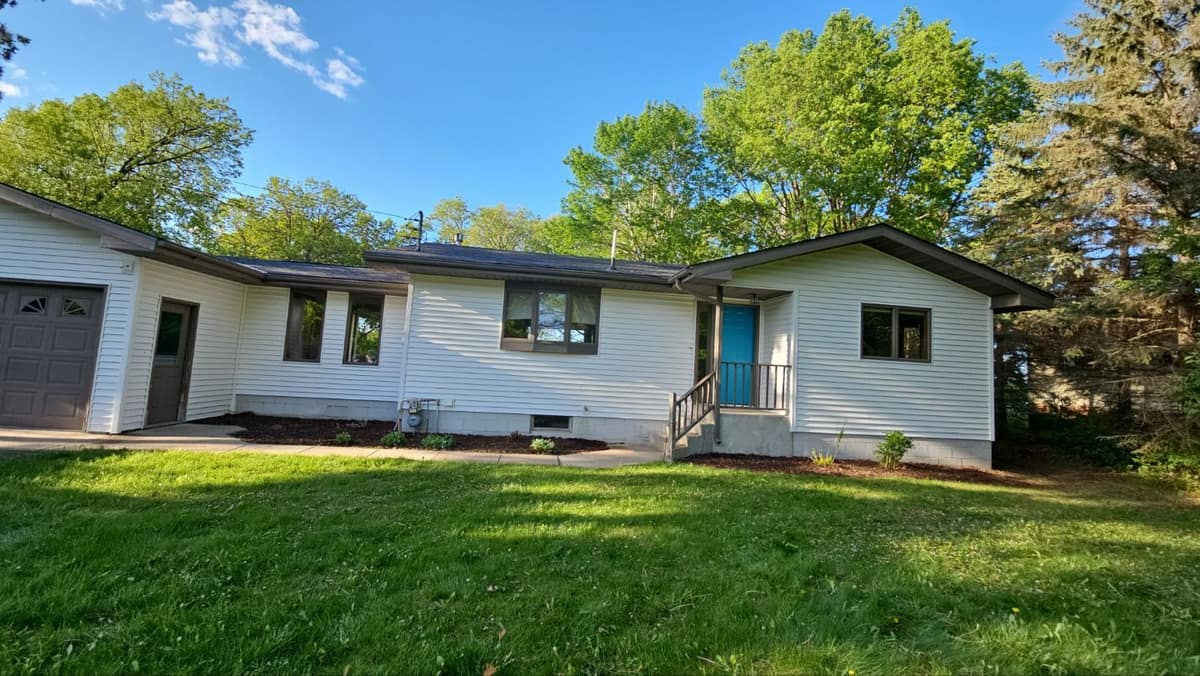 Single-story Sartell home with new white vinyl siding, a teal door and a new roof