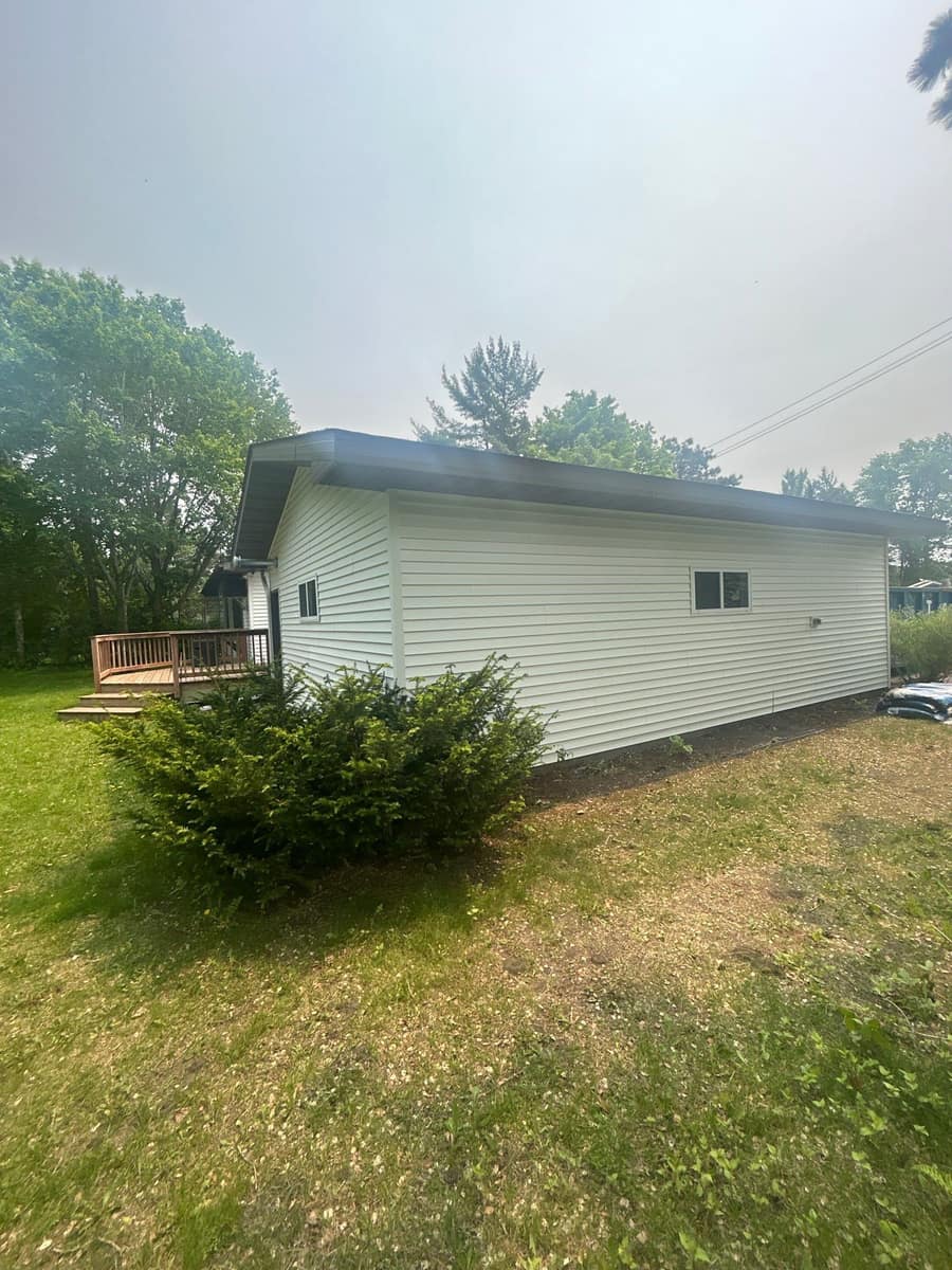 Long side of the Sartell home with new white siding under the new roof