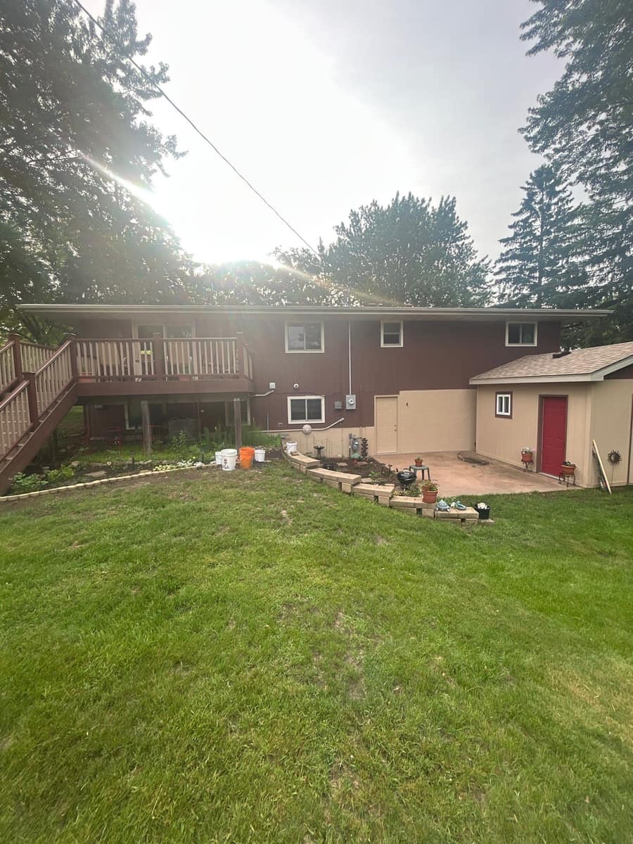 Back of a split-level Sauk Rapids, MN home with a deck under a new shingle roof