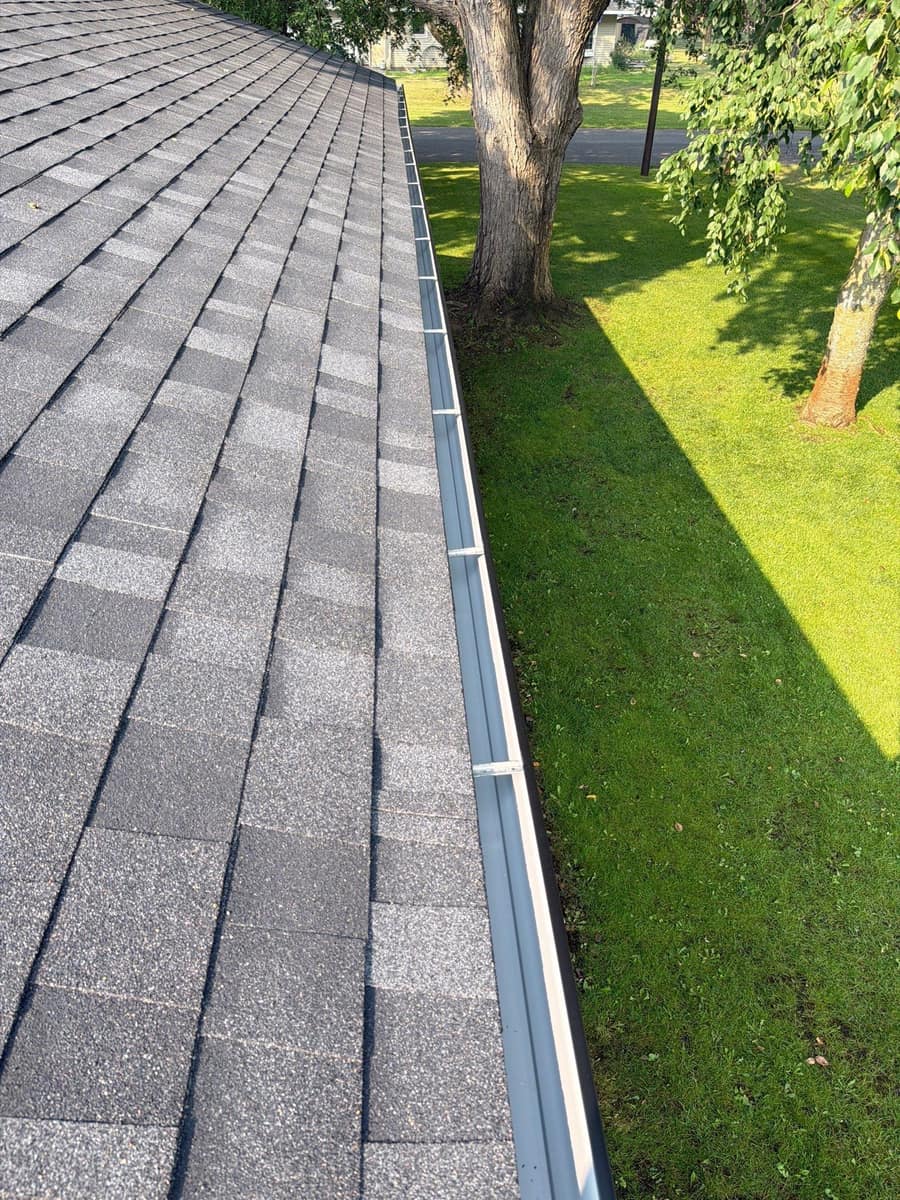 New gray shingles above a new gutter on the St. Cloud roof