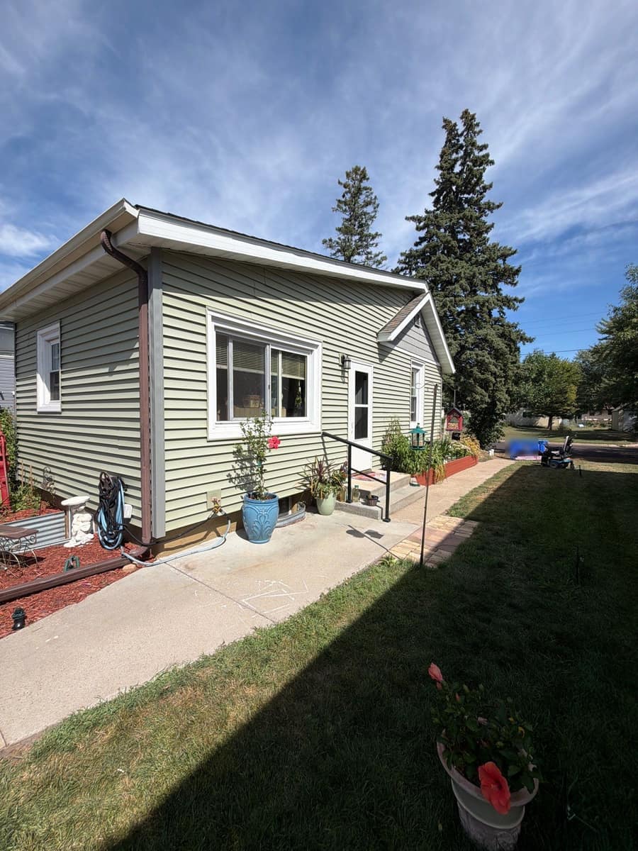 Corner of the St. Cloud home with new roof edge and gutter above the side entry