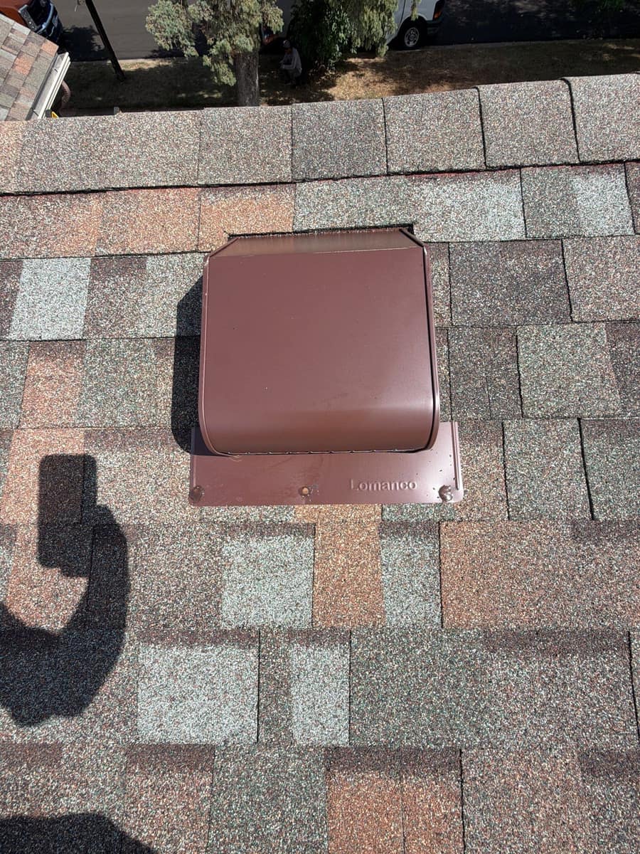 Close view of a brown roof vent set into new shingles in St. Cloud