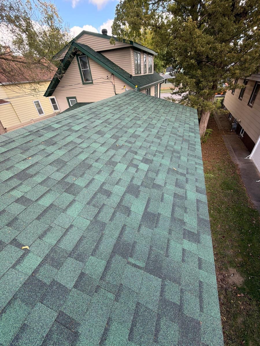 New green blend shingles on the long roof of the St. Cloud home