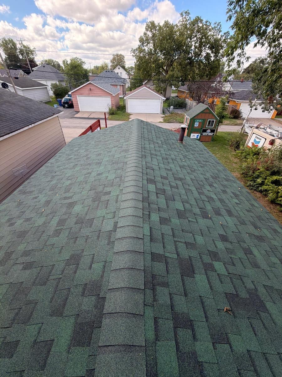 Ridge line of the new green shingle roof in St. Cloud