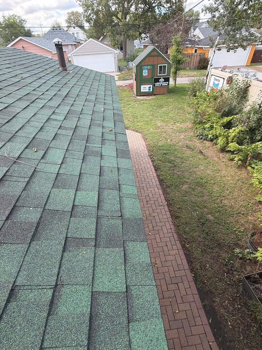 New green shingles above a brick walkway on the St. Cloud home