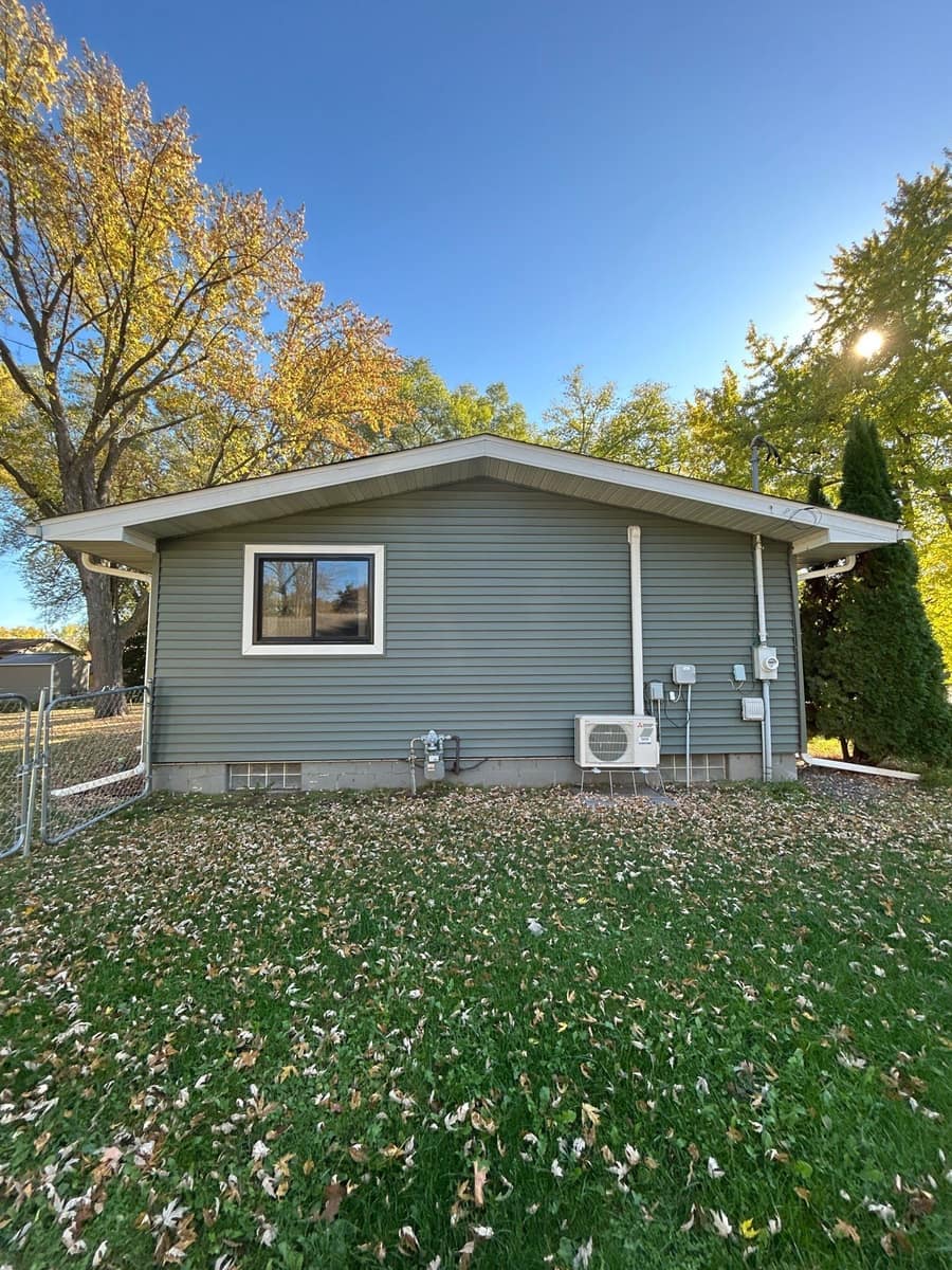 Back of a St. Cloud ranch home with new gray-green vinyl siding and a new roof